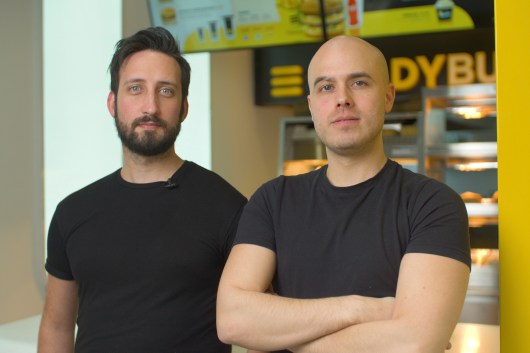 Two people in black shirts looking at camera